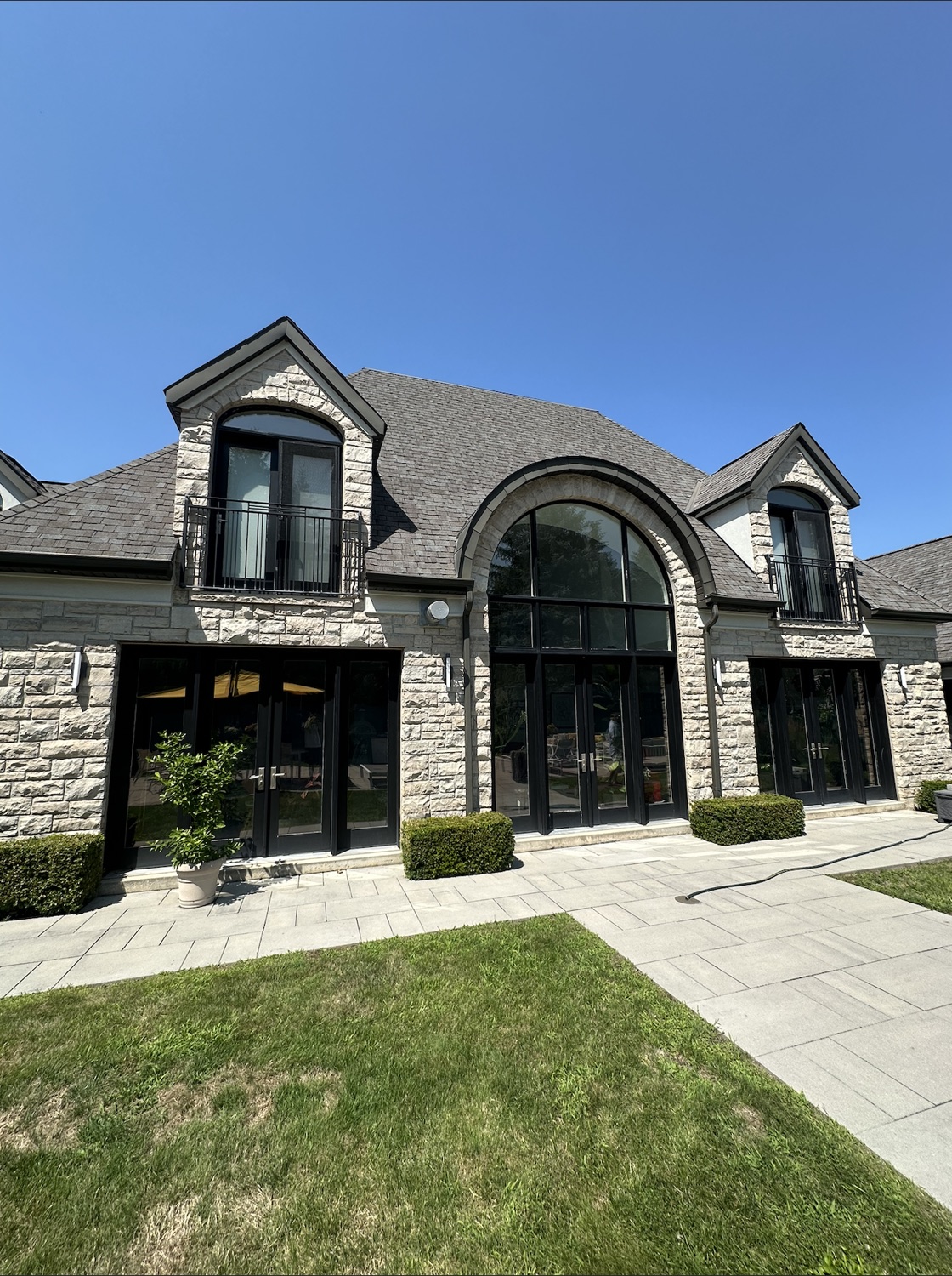 A luxury stone home with large arched windows cleaned by TrueClarity